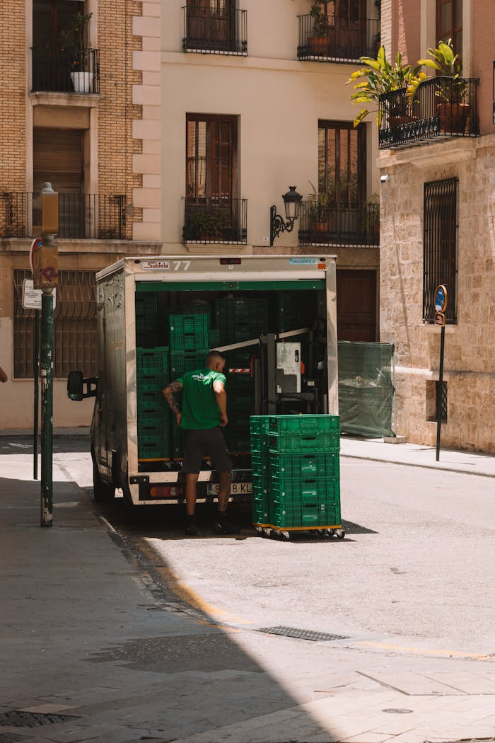 Busy street in Valencia, Spain with a delivery truck unloading crates.